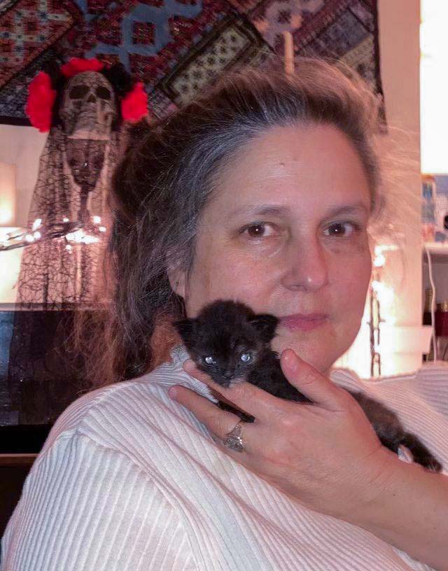 Head shot of Angela Davis with a kitten on her shoulder.