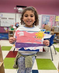 Young child holding up her color poster.