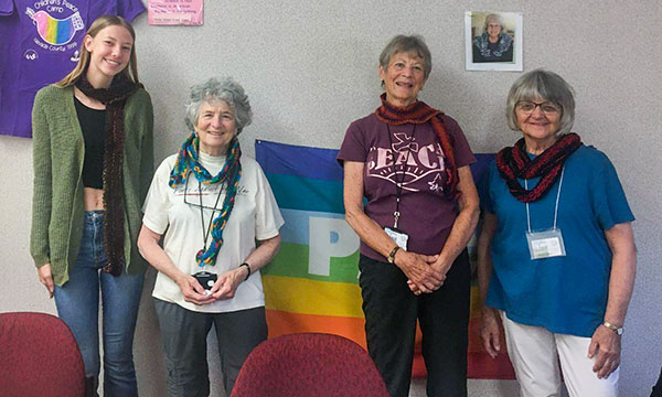 4 women stand in front of a classroom pin board.