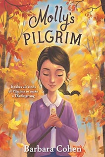 Illustrated book cover Molly's Pilgrim features a girl in a purple sweater walking on a path with red and yellow trees.