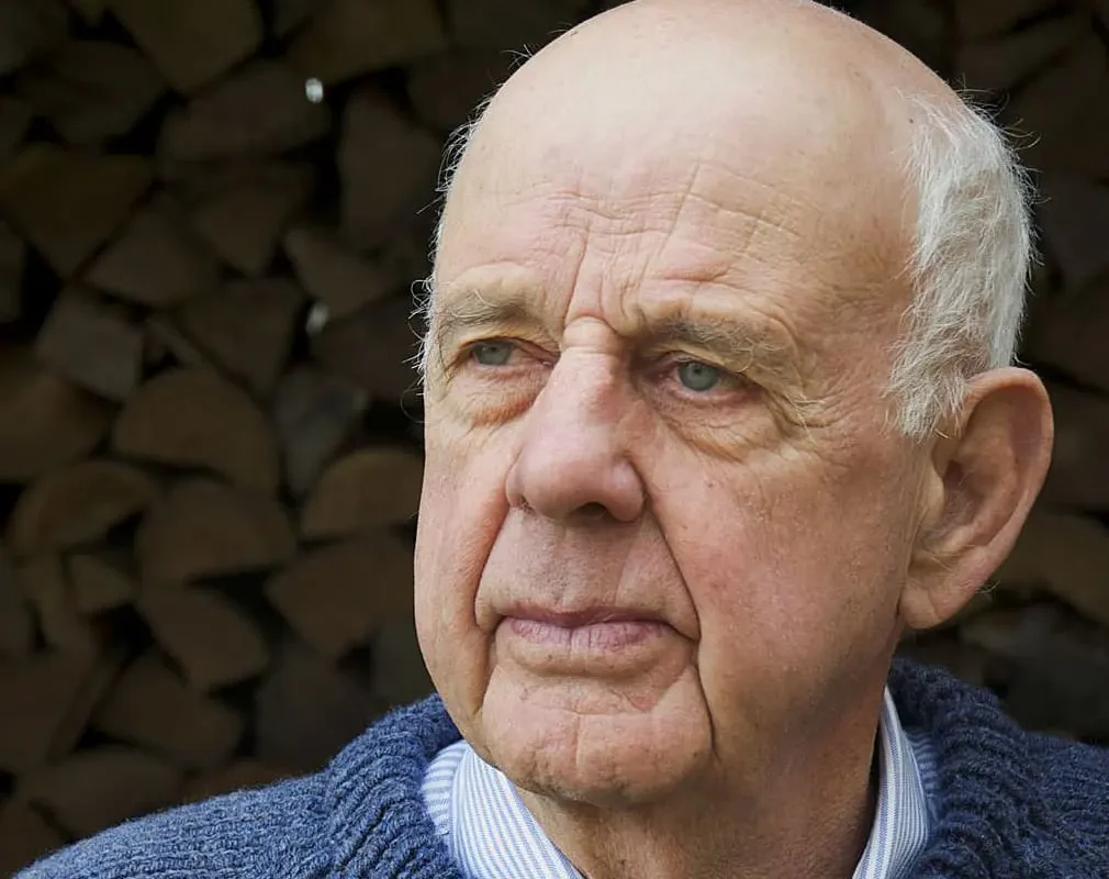 Headshot of Wendell Berry, a senior man with white hair wearing a blue sweater.