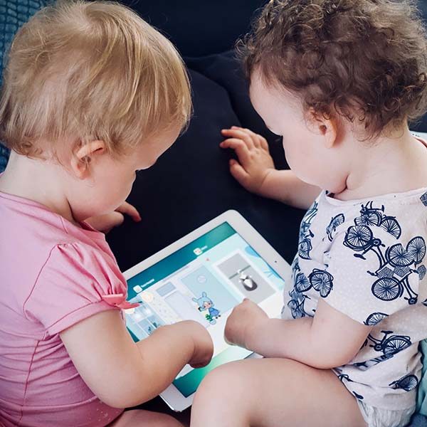 2 toddlers playing together on a tablet computer