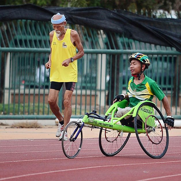 A runner and a wheelchair racer on a track