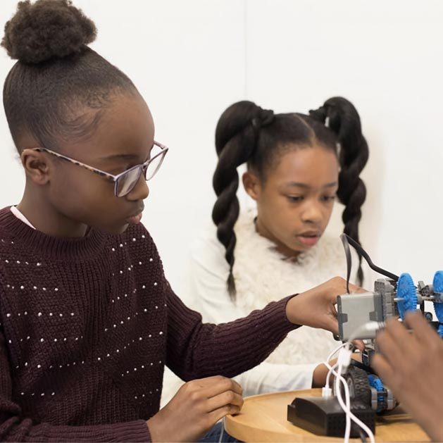 Children look at technical, science equipment
