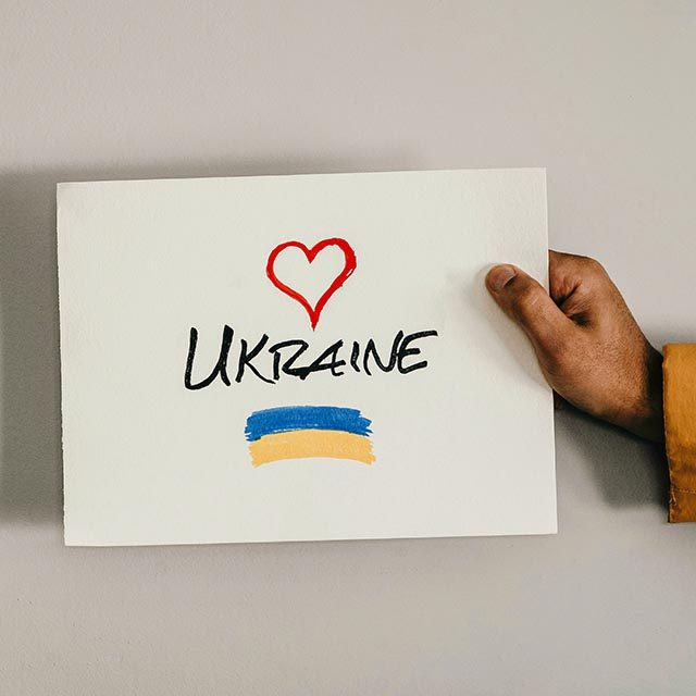 A hand holds out a large card with a heart icon, the word 