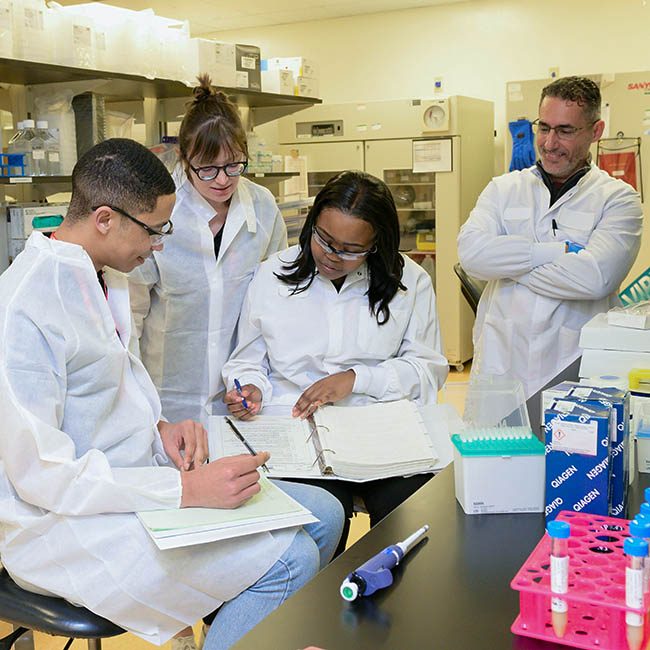 A researching oversees 3 lab tech trainees.