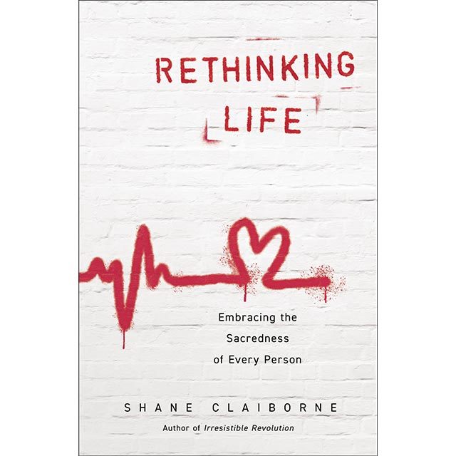 Book cover for Rethinking Life with the title in red stencil letters on a white painted brick wall
