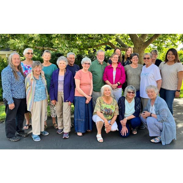 A group photo of a the PEACE board outside under a tree during their 2023 retreat