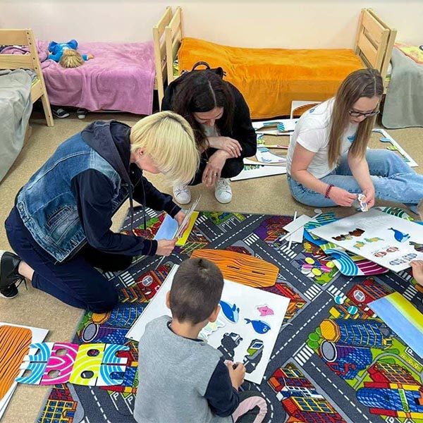 A group of Ukrainian adults and children enjoy activity and coloring books