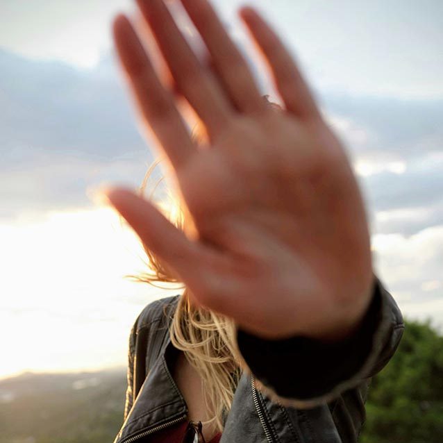 a woman holds up her hand to the camera in a stop motion