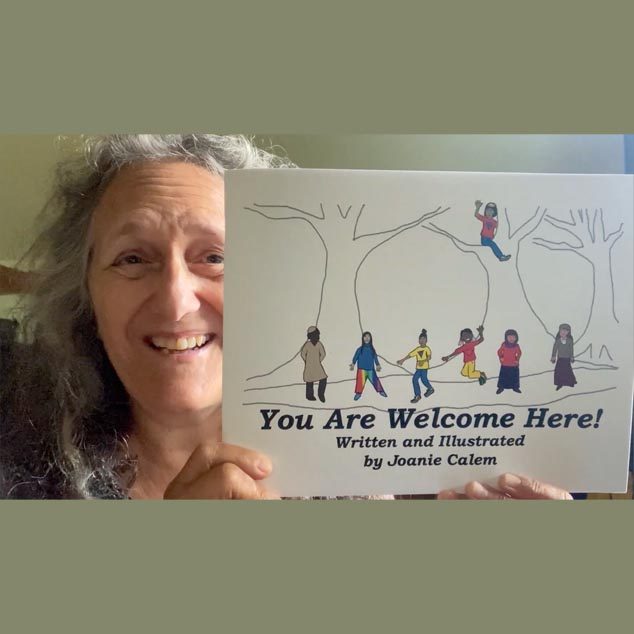 Joanie Calem holding up a copy of her children's book, You Are Welcome Here.