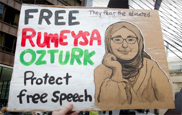 Cardboard sign reading Free Rumeysa Ozturk. Protect free speech. They fear the educated.