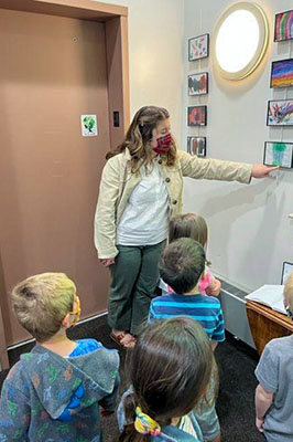 A teacher giving a gallery tour to pre-school children